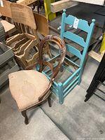 Brown upholstered chair and turquoise ladder-back chair side by side, showing condition and missing seat