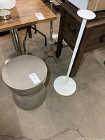 Resin stool and metal pedestal next to table for scale