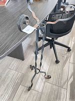 Full view of plant stand showing three twisted legs and scroll arms