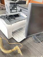 HP LaserJet Pro M12w printer front with Acer monitor beside