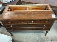 Front view of cabinet showing four drawers and flip-out top opening