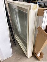 Full view of vinyl window standing on edge showing cream frame and glass