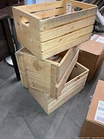 Three stacked unfinished slatted wood crates showing exterior surfaces and handles