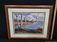 Front view of framed print with ducks over lake