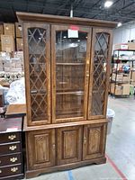Full view of china cabinet showing upper glass doors with lattice, lower wood doors