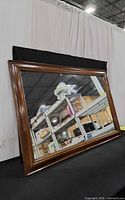 front view of large wooden framed mirror leaning against backdrop
