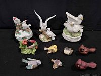Overview of all nine bird figurines on black background