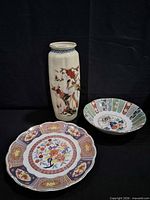 Front view of vase, charger and dish showing decoration