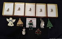 Group shot of all twelve Christmas themed pins including five boxed pieces and seven assorted loose pins