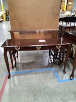front view of wood console table showing legs and drawer fronts