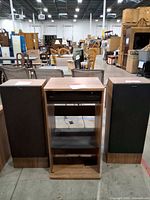 Front view of two Sony speakers flanking wood-veneer stereo cabinet