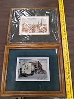 Overall view of both framed prints beside ruler for scale