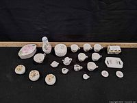 All items laid out including miniature tea set pieces, trinket boxes, vase, tray and floral figurines