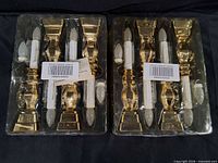 front view of two sealed 4-packs showing eight gold-tone window candles
