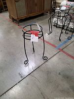 Front view of one plant stand showing height, leg style and overall design