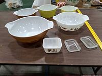 Group shot showing three mixing bowls, refrigerator dish and two lids on table