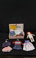 Lot overview showing doll, trunk and clothing laid out