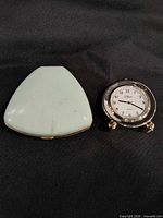 Closed Westclox case beside Collezio clock