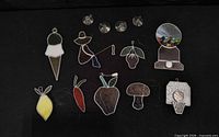 All nine stained glass pieces and four suction cup hangers on black background