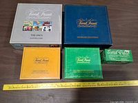 Five Trivial Pursuit boxed games arranged on table