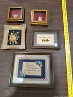 Front view showing all five framed art pieces with ruler for scale