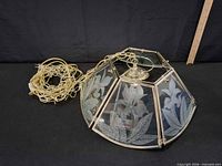Entire chandelier showing glass panels with etched flowers and attached chain