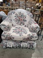 Front view of floral upholstered armchair showing entire piece and skirt detail