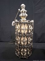 front view showing ornate metal lattice and cream inner shade
