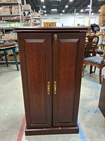 Full view of closed media cabinet with key in lock