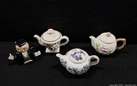 Group shot of all four ceramic teapots displaying styles and condition