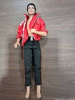 Full view of doll front: red jacket, black pants, no shoes