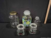 Five glass jars of varying sizes displayed