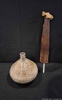 Glass vase and folded parasol side by side