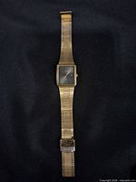 Front view of gold-tone Citizen wristwatch showing square case, dial and band