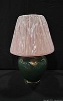 Full view of assembled lamp showing green base and pink pleated shade