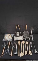 Overall view of kitchen utensil assortment laid out on black backdrop