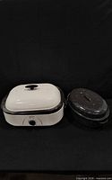 Rival roaster oven and speckled enamel roasting pan side by side