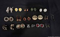 All twenty earring pairs arranged in grid on black background