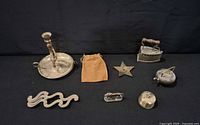 Entire group of seven metal decor pieces on dark backdrop
