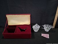 Open velvet box showing interior compartments and Crystal Legends card beside creamer and sugar bowl