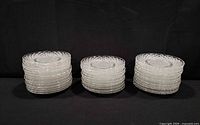 Three stacks of clear diamond pattern glass plates