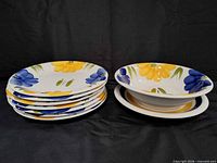 Stack of six shallow daisy bowls next to deep bowl on plate