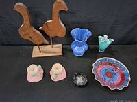 Group shot of entire lot showing wooden bird sculpture, both glass vases, ceramic dish, candle holders, ashtray