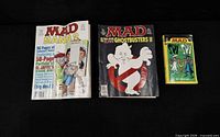 Three MAD publications laid out: two magazines and one paperback