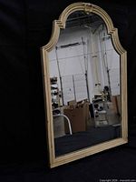 front view showing full mirror, arched frame, carved crest