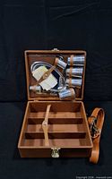 open case showing all components: flask, four tumblers, spoon, napkins, interior compartments