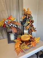 Overall view of both lanterns with swags, pillar candle, wreath and basket