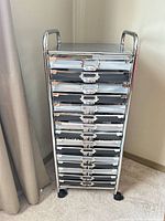 Full view of chrome rolling cart showing all 15 drawers and casters