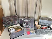 Overview of storage boxes on table with ribbon spools and bag of supplies