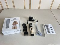 Full kit laid out: box, clipper, adapter, oil, four guide combs, scissors, metal comb, manual